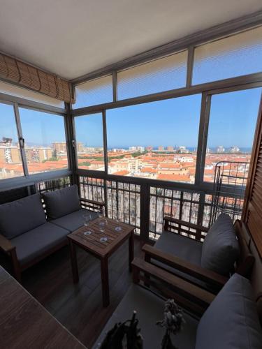 een woonkamer met banken en een tafel bij 3 Bedrooms Apt WITH THE SEA VIEW in Málaga