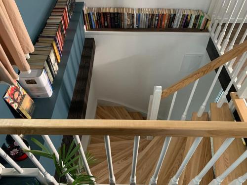 a spiral staircase with dvds and books at Lovely Tiny House in Kelmė
