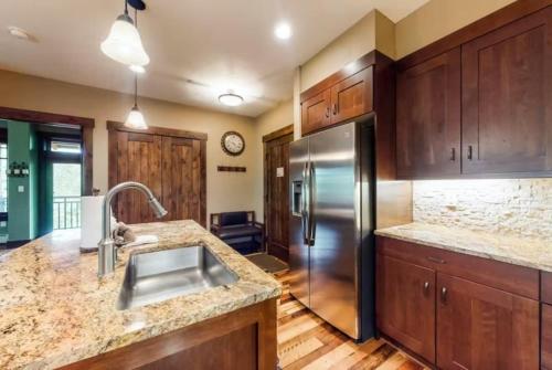 布雷肯里奇2 Bedroom Luxury Condo On Main Street At Maggie Pond - Walk To Lift!的厨房配有不锈钢冰箱和木制橱柜