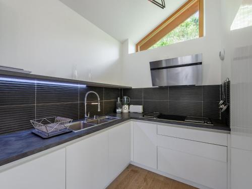 une cuisine blanche avec un évier et une fenêtre dans l'établissement Chalet moderne à Méribel : jacuzzi, sauna, 6 chambres, proche centre et navette - FR-1-565-55, à Les Allues