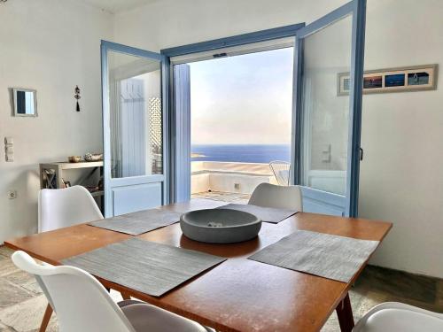 a dining room with a table with a view of the ocean at Sunny Stone Tinos House in Tinos