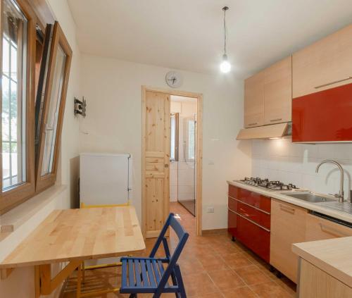 uma cozinha com uma mesa de madeira e um frigorífico em Residenza alla Battaglia em Villa Castelli