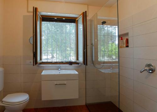 uma casa de banho com um WC, um lavatório e uma janela em Residenza alla Battaglia em Villa Castelli