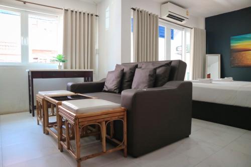 a living room with a couch and a bed at Sunshine Guest House in Hua Hin