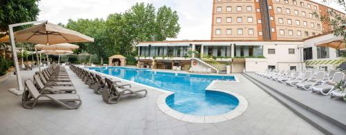 a swimming pool with lounge chairs and umbrellas at a hotel at Best Western Plus Congress Hotel Yerevan in Yerevan