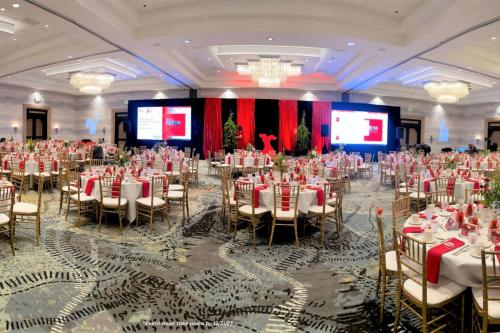 a banquet hall with tables and chairs and two screens at DoubleTree by Hilton Modesto in Modesto