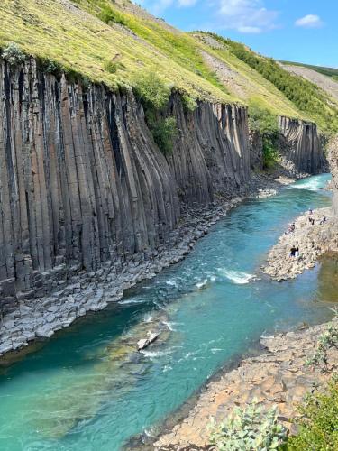 a river running through a canyon with cliffs at Jökla Guesthouse in Skjöldólfsstaðir