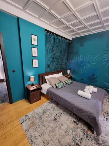 1 dormitorio con 1 cama grande y paredes azules en Deisisroomnafplio Zeus στ κέντρο του παλιο Ναύπλιο en Nafplio