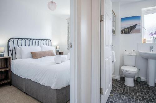 a bedroom with a bed and a sink and a toilet at Swn Y Mor - 4 Bedroom Holiday Home - Llanelli in Llanelli