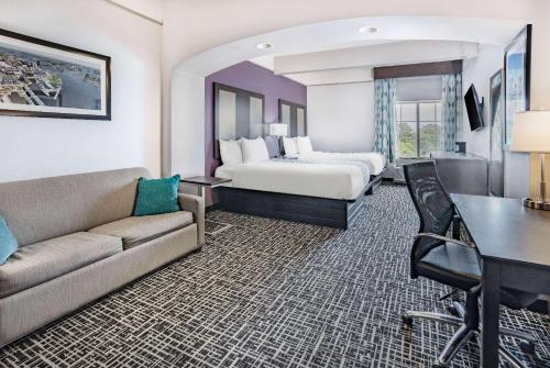 a hotel room with a bed and a couch at La Quinta Inn & Suites by Wyndham Norfolk in Norfolk