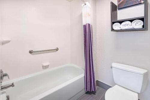 a bathroom with a white tub and a toilet at La Quinta Inn & Suites by Wyndham Norfolk in Norfolk