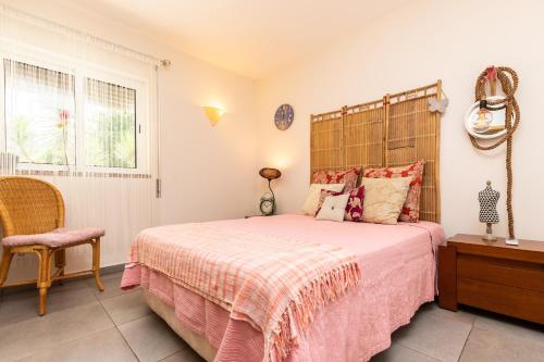 a bedroom with a bed and a chair and a window at Santa Luzia Green Apartment in Santa Luzia