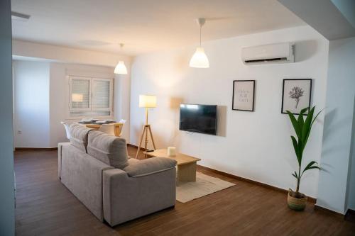 - un salon avec un canapé et une télévision dans l'établissement California Apartament Dueñas, à Séville