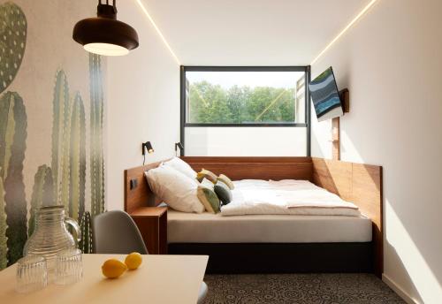 um quarto com uma cama e uma janela em TIN INN Montabaur l einfach gut - Das Hotel aus hochwertig ausgebauten Überseecontainern em Montabaur
