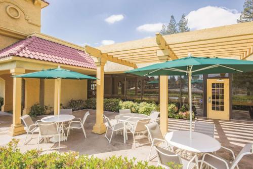 a patio with tables and chairs and umbrellas at Howard Johnson by Wyndham Sacramento Downtown in Sacramento