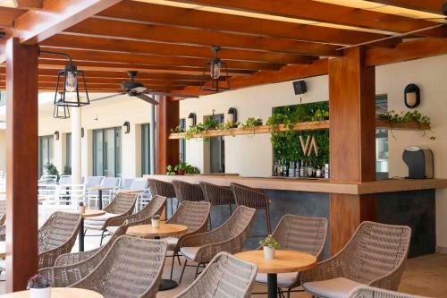 a restaurant with tables and chairs and a bar at Valentin Star Menorca - Adults Only in Cala'n Bosch
