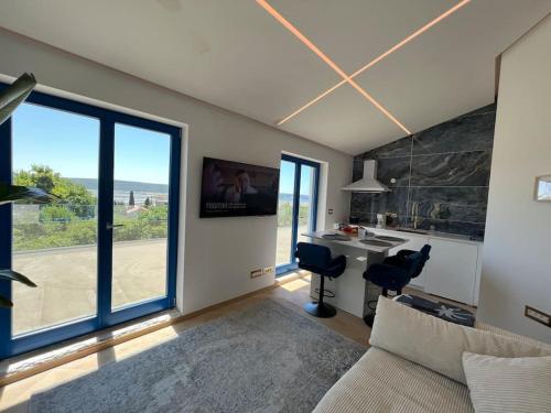 a living room with a couch and a desk and windows at Sea view 2 bedroom apartment in Portorož