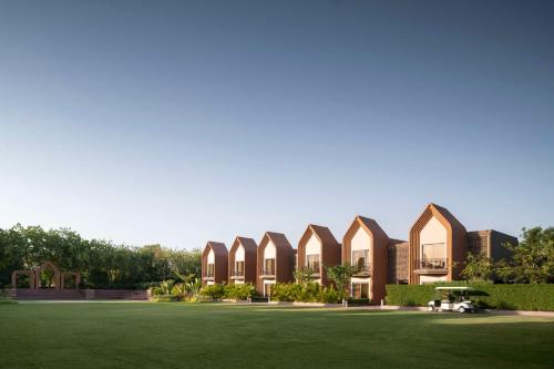 a building with a green lawn in front of it at Radisson Hotel Kandla in Gandhidham