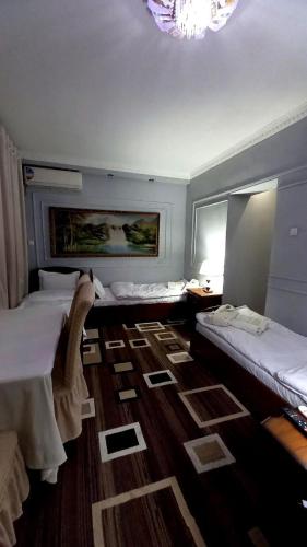a bedroom with two beds and a chandelier at UYUT INN Hotel in Samarkand