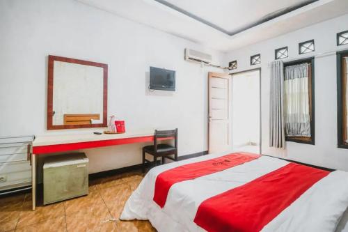 a bedroom with a bed and a desk and a mirror at RedDoorz Plus at Neo Asri Hotel Megamendung Puncak Bogor in Bogor