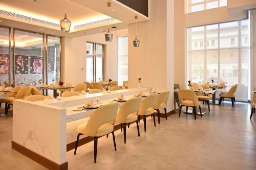 a dining room with tables and chairs and windows at Comfort Hotel Riyadh Olaya in Riyadh