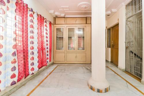 un corridoio con tende rosse e bianche e una colonna di OYO Hotel Kalyug Palace a Bhopal