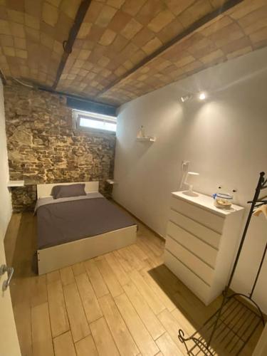 Dormitorio pequeño con cama y pared de piedra en Taverna Bucciante, en Fossacesia