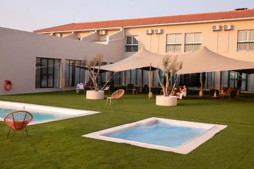 un complejo con piscina y un edificio en Estremoz Hotel, en Estremoz