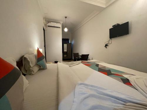 a room with a bed and a flat screen tv at Baga View Inn in Baga