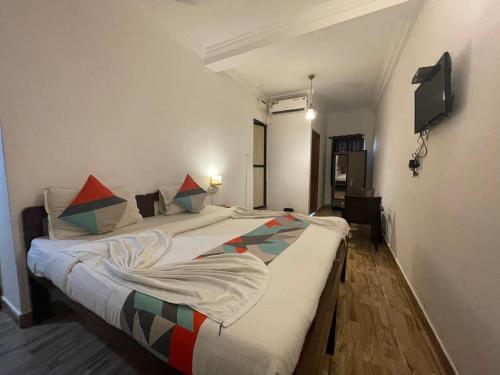 a bedroom with two beds and a flat screen tv at Baga View Inn in Baga