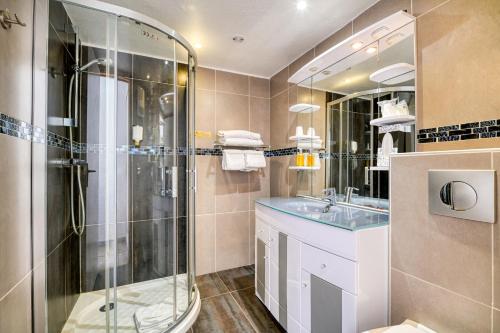 een badkamer met een douche en een wastafel bij Hôtel La Nartelle in Sainte-Maxime