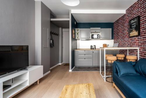 uma sala de estar com um sofá azul e uma cozinha em Appartement Hyper Centre, Avenue de Champagne à 200 mètres em Épernay