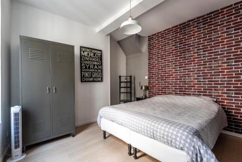 um quarto com uma parede de tijolos e uma cama em Appartement Hyper Centre, Avenue de Champagne à 200 mètres em Épernay