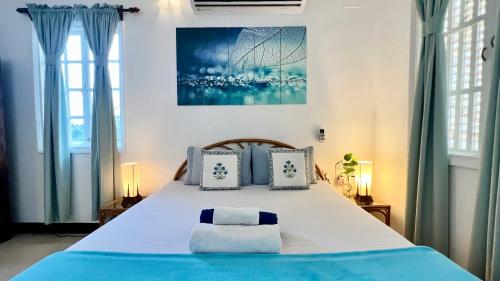 a bedroom with a large bed with two pillows at Nestwood - By The Beach Goa in Benaulim