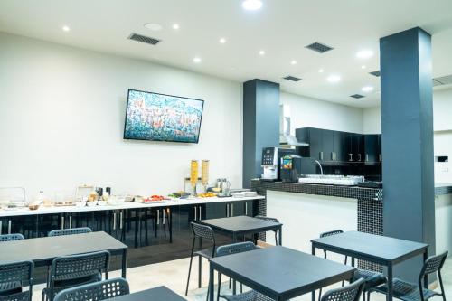 un ristorante con tavoli e sedie e una cucina di New Amaryllis Hotel ad Atene