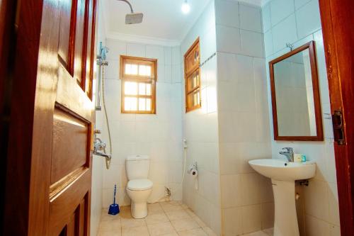 ein Bad mit einem WC und einem Waschbecken in der Unterkunft Bamboo Village in Arusha