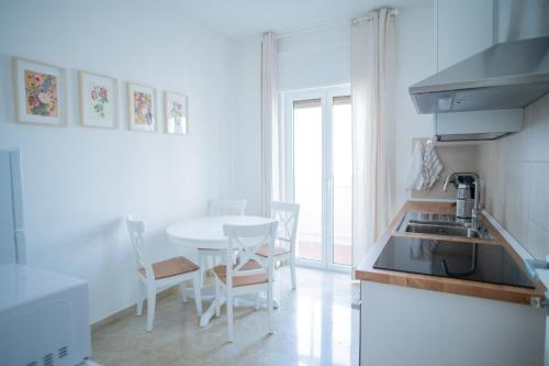 eine Küche mit einem Waschbecken und einem Tisch mit Stühlen in der Unterkunft Dall Arca Smart Flat - Central Station Checkpoint in Bari
