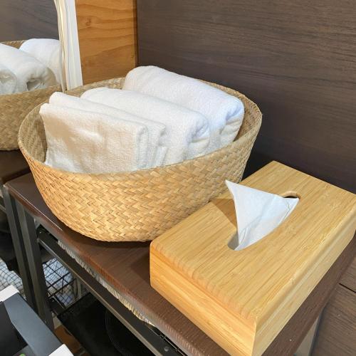 a basket of towels on a table with a box at R Garden in Yamanakako