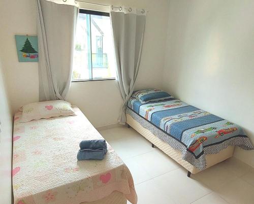 a bedroom with two twin beds and a window at Casa em Condomínio Fechado com Sauna e Piscina in Salinópolis