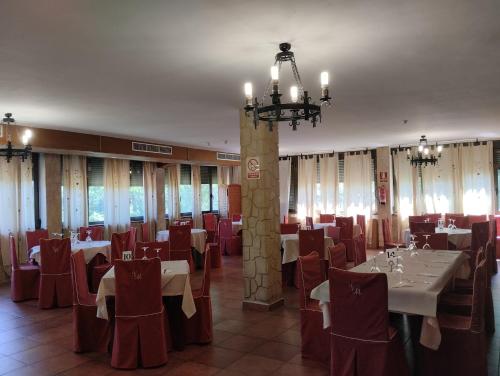 a banquet hall with tables and chairs and a chandelier at Hotel Condado de Miranda in Miranda del Castañar