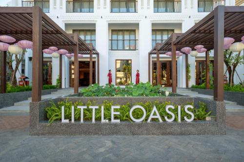 een bord dat kleine oase voor een gebouw leest bij Little Oasis - An Eco Friendly Hotel & Spa in Hội An