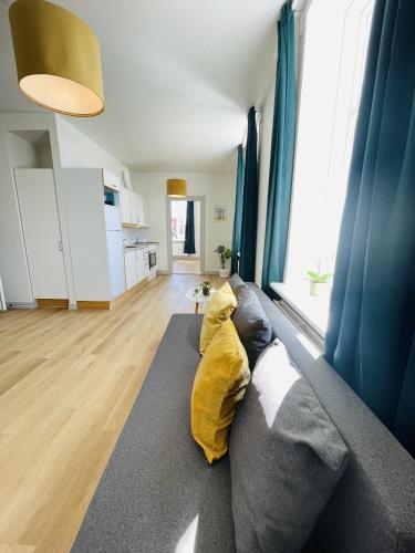 a living room with a couch with a yellow blanket at aday - Green Light Apartment Suite in the center of Hjorring in Hjørring
