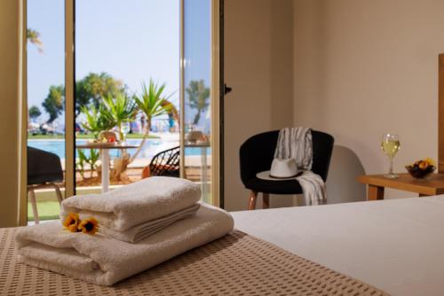 Pokój hotelowy z łóżkiem z ręcznikami i balkonem w obiekcie Malia Bay Beach Hotel & Bungalows w mieście Malia