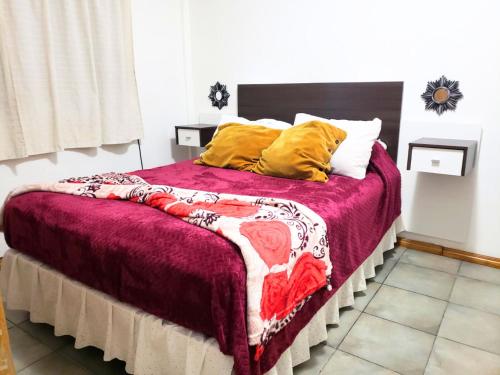 1 dormitorio con 1 cama grande con manta morada y almohadas amarillas en Departamento a una Cuadra del Obelisco - Microcentro - en Buenos Aires