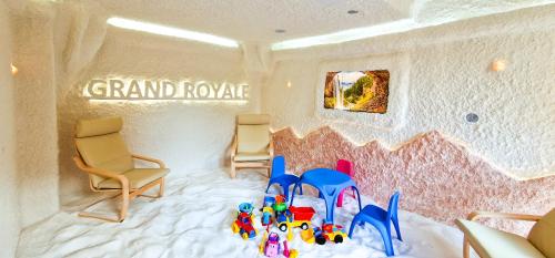 a room with chairs and toys on a bed at Grand Royale Apartment Complex & Spa in Bansko