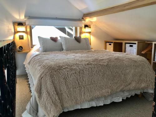 a bedroom with a large bed with a window at Chalet La Bohème in Prouilly