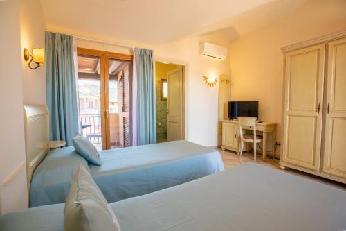 ムルタ・マリアにあるホテル ダニエルのベッド2台とテレビが備わるホテルルームです。