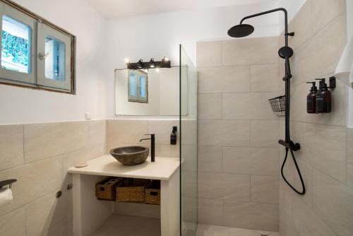 uma casa de banho com um chuveiro e um lavatório. em Malethonas Cottage by All About Paxos em Gaios