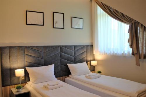 a bedroom with two beds and a window at Villa & Gospoda Krakowska in Kobiernice