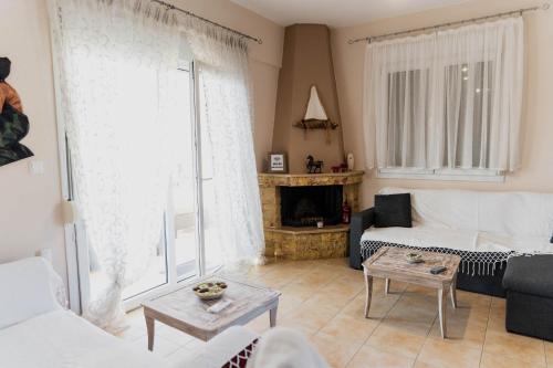 a living room with a couch and a fireplace at Villa de N.A.P.E in Hanioti